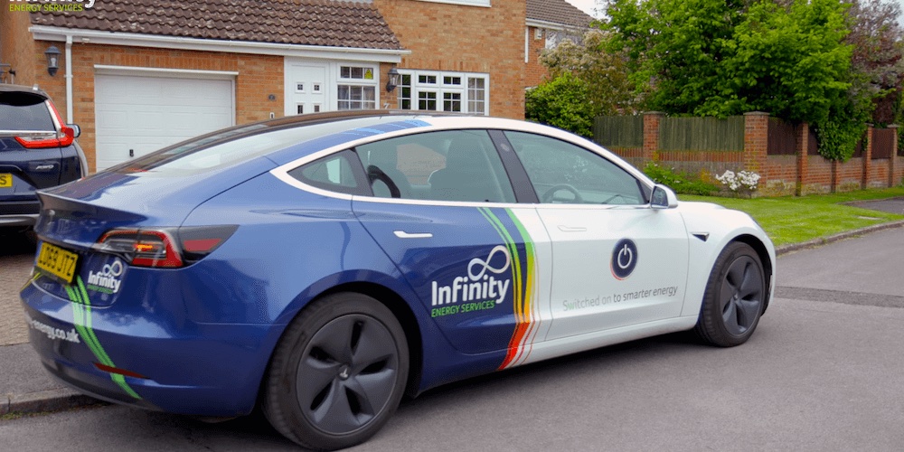 free-no-obligation-west-sussex-battery-survey An Infinity Energy Services branded Tesla Model 3 parked outside a residential property in West Sussex, ready for a free battery storage survey