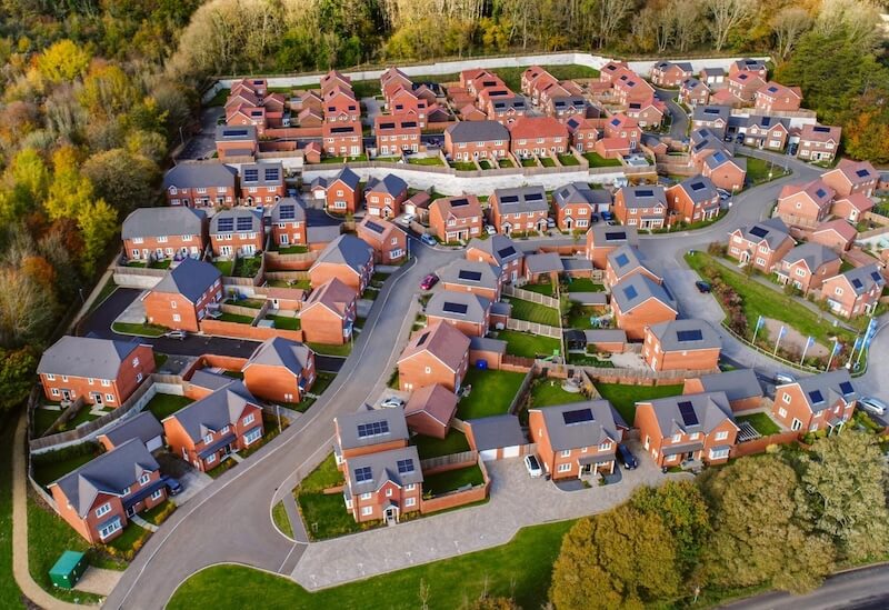 planning-permission-for-solar-panels-in-west-sussex Aerial view of a West Sussex village with rooftop solar panels showing typical planning permission considerations