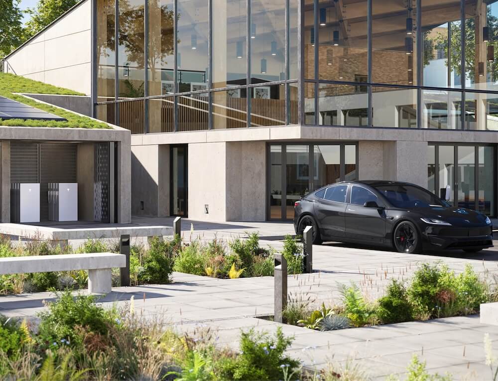 tesla-powerwall-commercial-installers-west-sussex A modern commercial building in West Sussex with Tesla Powerwall battery units installed alongside solar panels and a Tesla electric vehicle